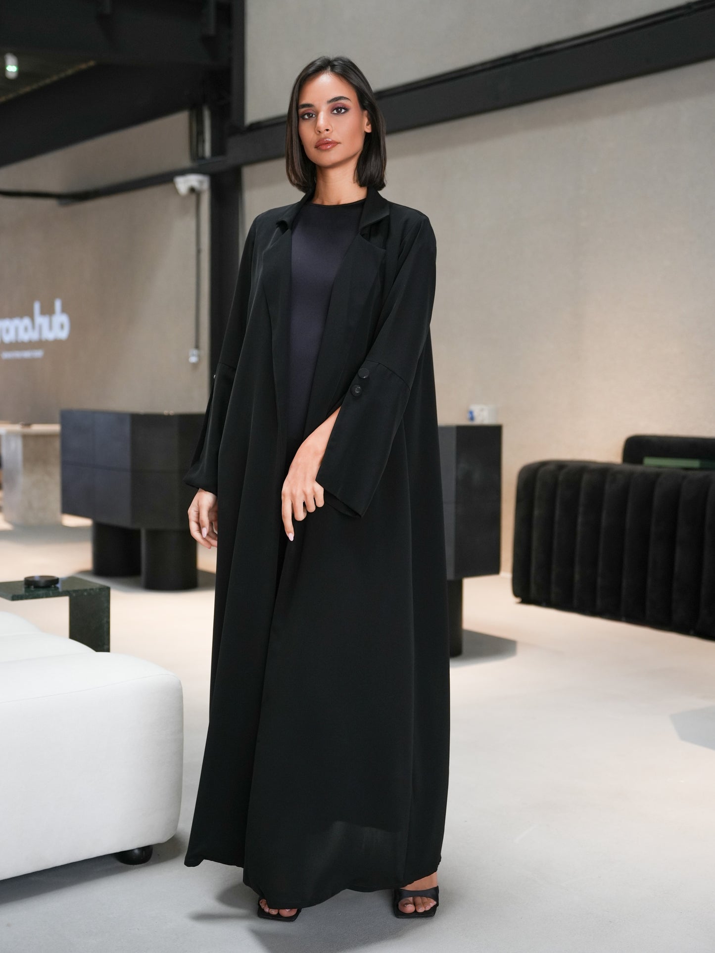 Collared abaya features slitted sleeves and covered button details